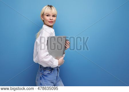 Young Successful Smart Blond Female Student Dressed In A White Blouse With A Laptop In Her Hands. Bu