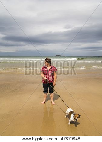 Lady Dog Walking sulla spiaggia
