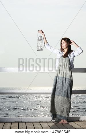 Flicka på bryggan med fotogenlampa