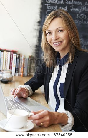 Businesswoman Using Laptop In Cafe