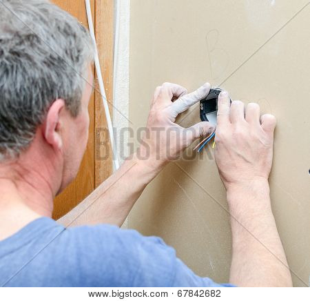 Certified Electrician Installing Socket For Light Switch.