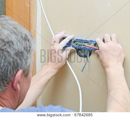 Certified Electrician Installing Socket For Light Switch.