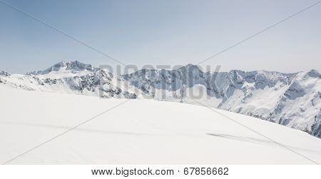 Snow Covered Slope With Mountain Ridge In The Back