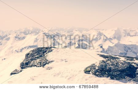 Snow Covered Rock With A Mountain View In The Back