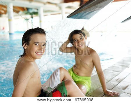 Happy little boys enjoying relaxing and splashing in water