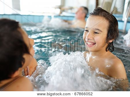 Happy little boys enjoying relaxing and splashing in water