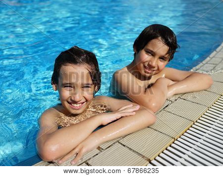 Happy little boys enjoying relaxing and splashing in water