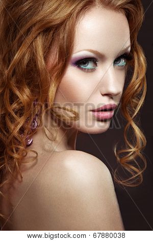 Beautiful red-haired girl with bright makeup and curls.