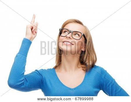 advertisement concept - attractive young woman in black eyeglasses pointing her finger up