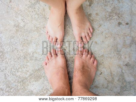 Couples  Feet On The Concrete Ground shallow depth on field