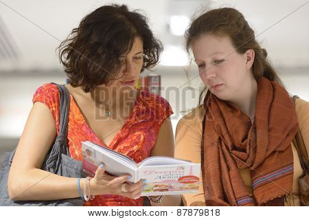 MOSCOW, RUSSIA - JULY 30, 2013: Women read the book of French dietitian Dr. Pierre Dukan during the meeting with readers of the magazine Marie Claire in Moscow, Russia on July 30, 2013
