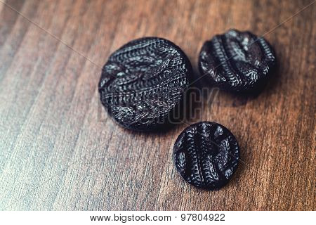 black buttons on wooden background