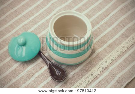 Green pastel porcelain jar and brown spoon in vintage style.