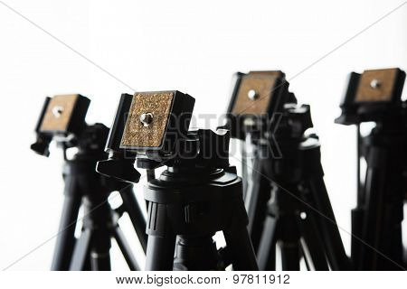 Multiple camera tripods ready for filming or photo session. Photography or filming equipment. 