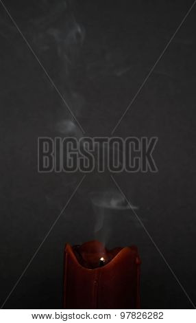 extinguished red candle with smoke