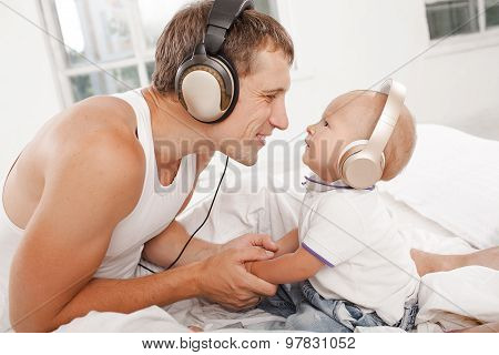 young father with his nine months old som on the bed at home