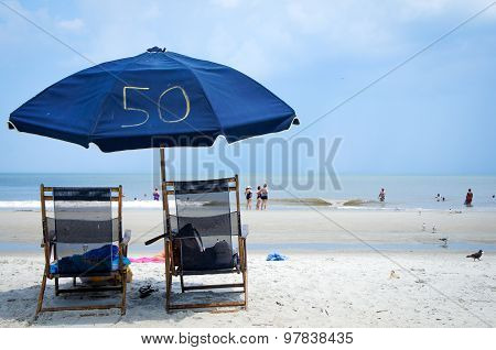 June 2015, Tybee Beach near Savannah, Georgia, USA -  Two beach chairs and umbrella at Tybee