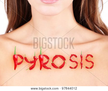 Word pyrosis made with red hot peppers on woman's body, Heartburn concept