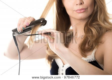 Closeup Of Young Woman Straightening Hair