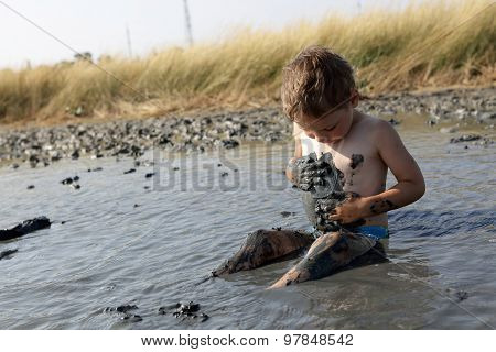 Boy Applying Black Healing Clay