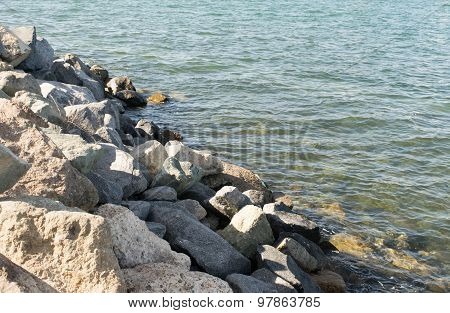 Rocky shoreline and ocean's edge with aqua water