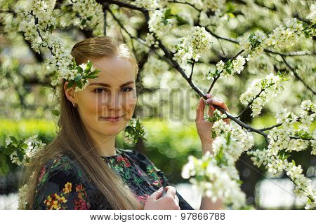 Beautiful girl standing in blossom garden