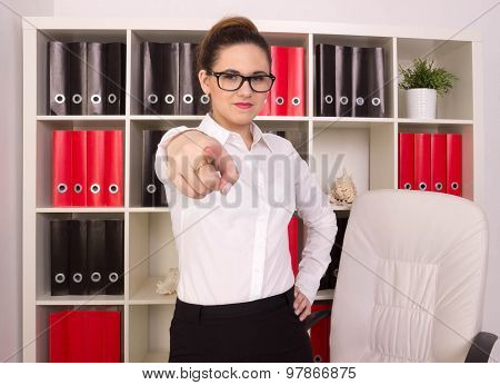 Angry usiness woman pointing at person in her office