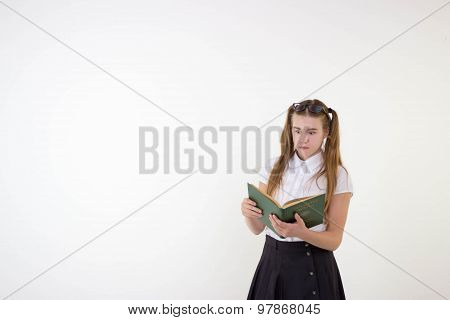 Schoolgirl with glasses surprised, reading book