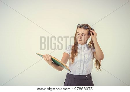 Schoolgirl with glasses surprised, reading book