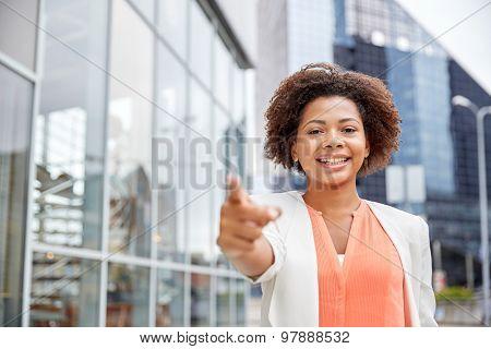 business, gesture and people concept - young smiling african american businesswoman in city pointing finger on you