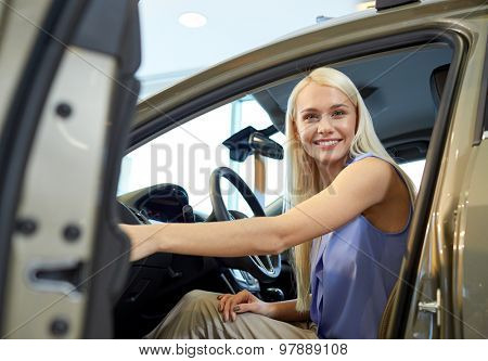 auto business, car sale, consumerism , transportation and people concept - happy woman sitting in or driving car
