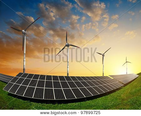 Solar panels with wind turbines in the setting sun. Concept of energy resources.