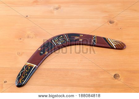 Traditional Ornamented Aborigine Boomerang On An Oak Wood Table