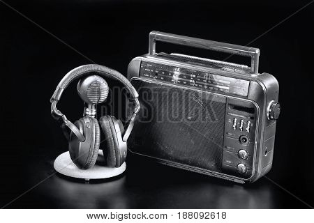 Old time radio with mic and headphones in black and white.