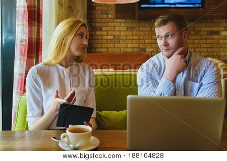 Business meeting in a cafe. Man and woman are negotiating.