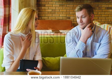 Business meeting in a cafe. Man and woman are negotiating.