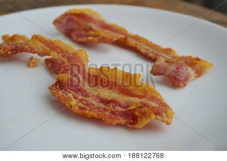 Macro detail of unhealthy crispy bacon strips as a symbol of typical American breakfast food