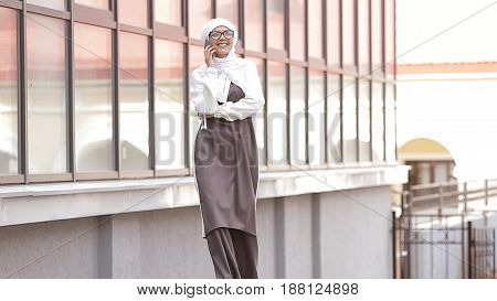 Young Muslim Girl Uses Smartphone and Laughing.