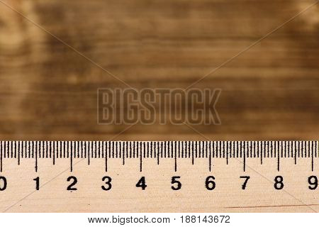 Ruler of wood on vintage wooden background with copy space selective focus. Minimalistic concept of precision measuring and accuracy