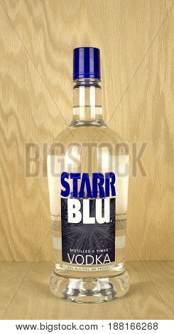 RIVER FALLS,WISCONSIN-MAY 25,2017: A bottle of Starr Blu brand vodka with a wood background.
