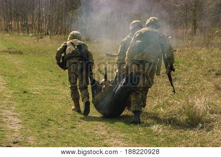 Military bear his wounded friend under gunfire