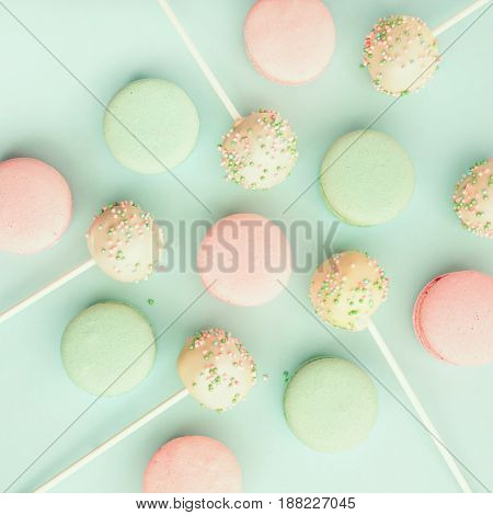 Colorful macaroons mixed with delicious cake pops. Top view. Flat lay