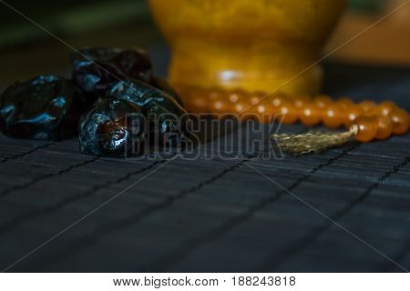 Date fruits or datulas with muslim beads for holy month of ramadan to break fasting from sunrise to sundown.