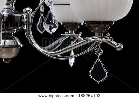 Classic Chandelier for interior decoration of the living room. Chandelier close-up photo isolated on black background. Silver modern a piece of interior for designers.