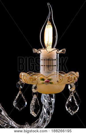 Classic Chandelier for interior decoration of the living room. Large chandelier close-up details decorated with crystals isolated on black background. Gold modern a piece of interior for designers.