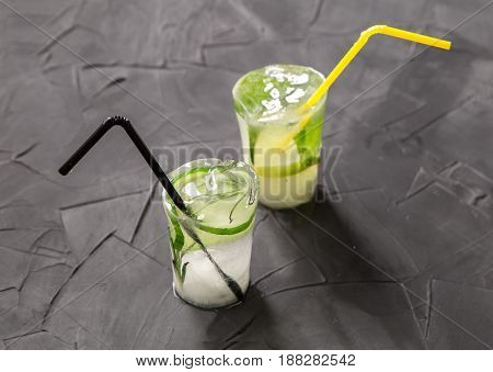 glass with fresh citrus cocktail made of ice on concrete table. concept