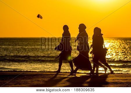 Kijkduin beach the Netherlands - May 26 2017: group of girls walking on beach at sunset during warm weather