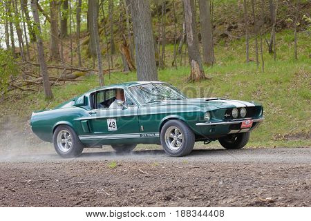 STOCKHOLM SWEDEN - MAY 22 2017: Green Shelby GT-350 classic car from 1967 driving on a country road in the public race Gardesloppet in the forests at Djurgarden Stockholm Sweden. May 22 2017