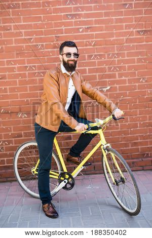 Cool Young Bearded Hipster Besides A Fixie Bicycle On Brick Wall On The Street