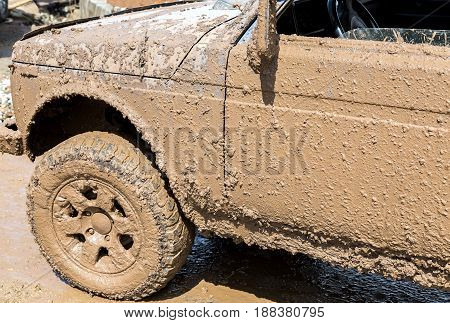 Off-road vehicle after driving in the rain on extremely dirty rural road
